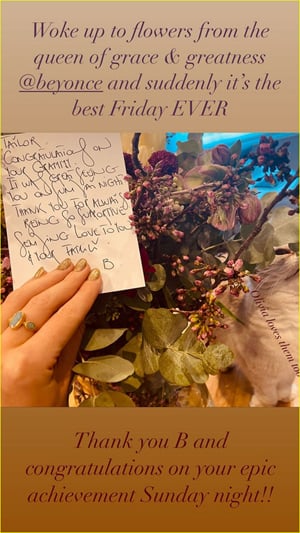 Taylor Swift holds a note in a flower bouquet
