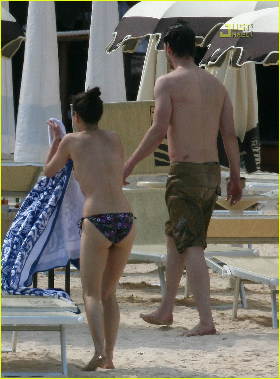 Keanu Reeves and topless female friend China Chow wade in the water togethe...