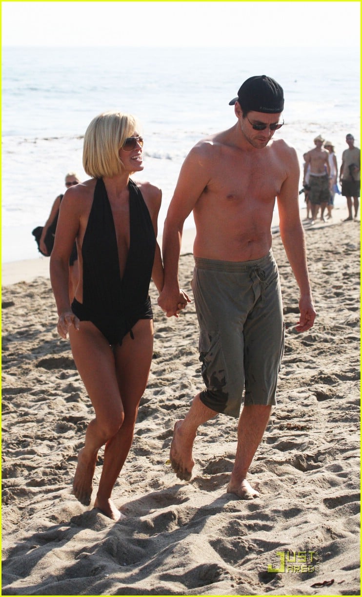 struts her stuff in a sexy black swimsuit while walking hand-in-hand with h...