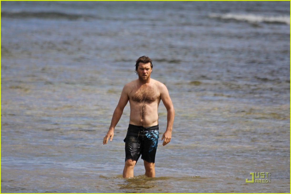 Sam Worthington goes shirtless as he takes a dip in the water while spendin...