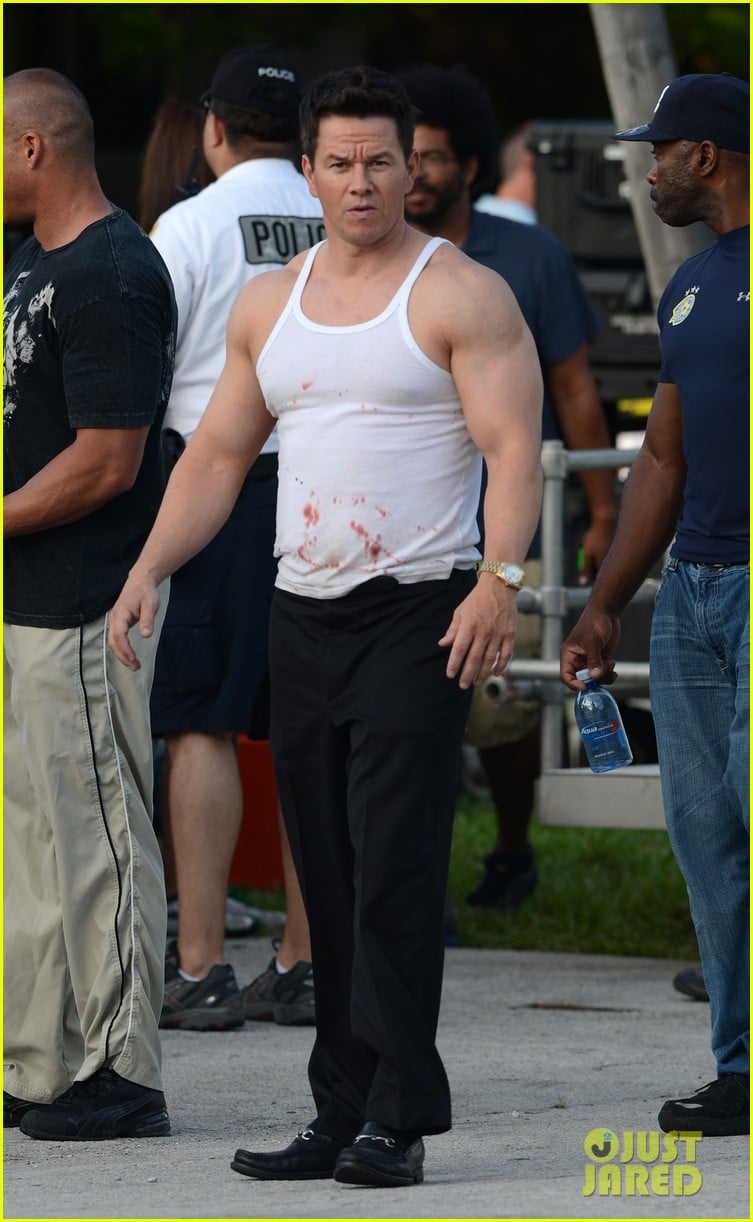 Mark Wahlberg shows off his bulging biceps in a tank top splattered with bl...