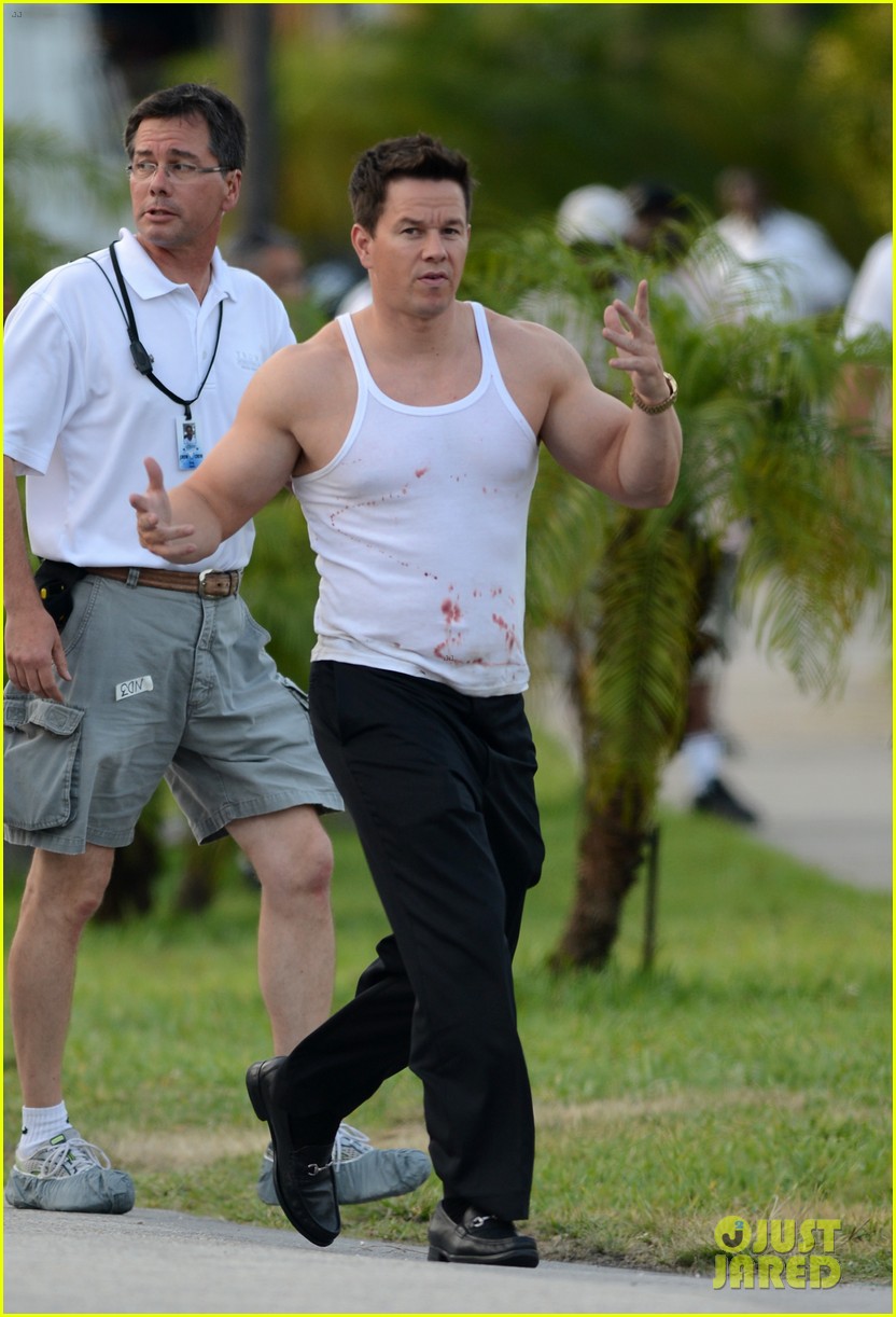 Mark Wahlberg shows off his bulging biceps in a tank top splattered with bl...