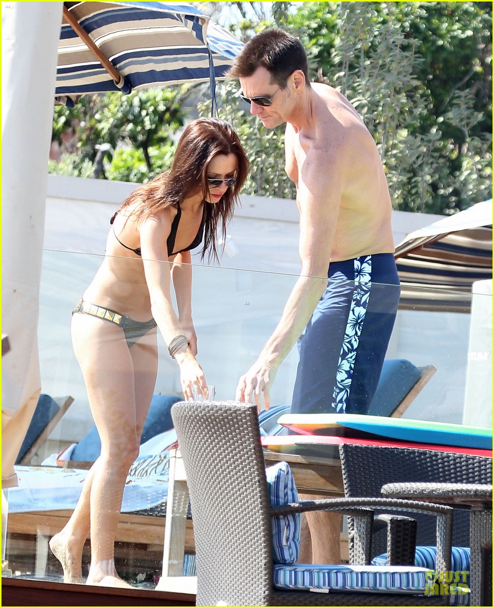 Jim Carrey shows off his shirtless body while on a beach with a mystery wom...