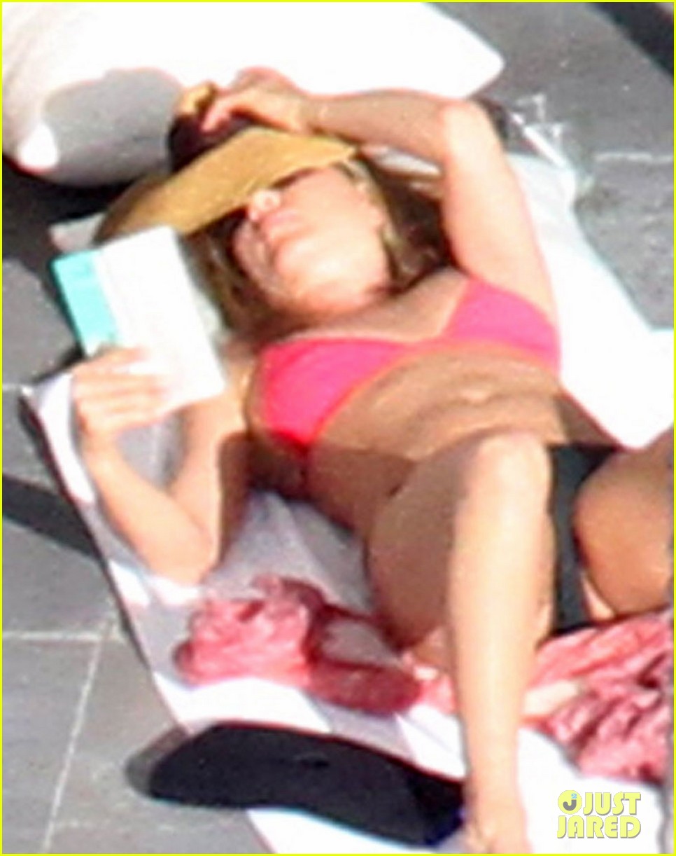 Jennifer Aniston wears a pink bikini top while sunbathing with her shirtles...