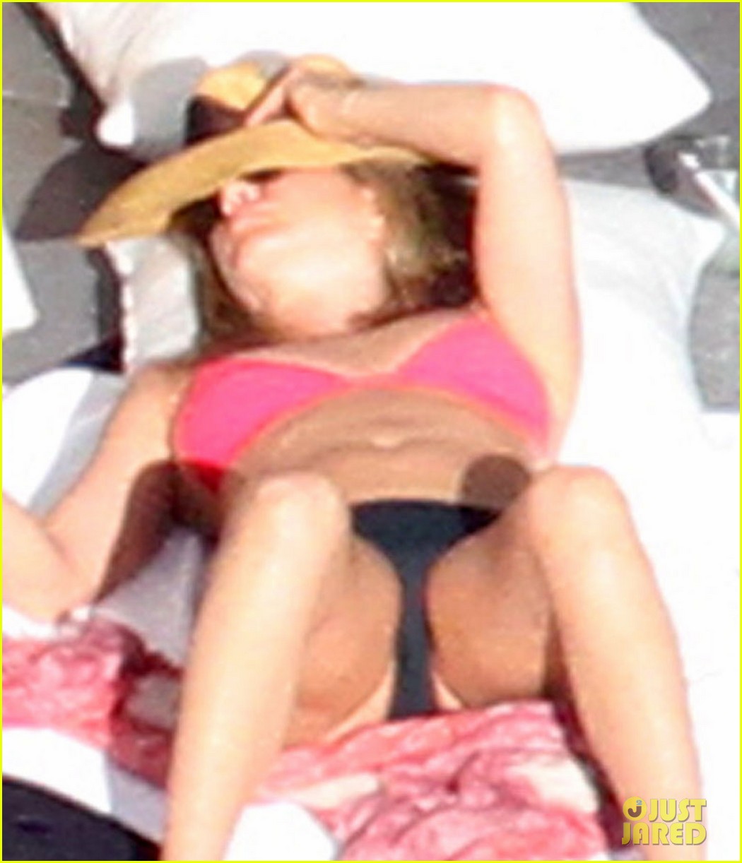 Jennifer Aniston wears a pink bikini top while sunbathing with her shirtles...