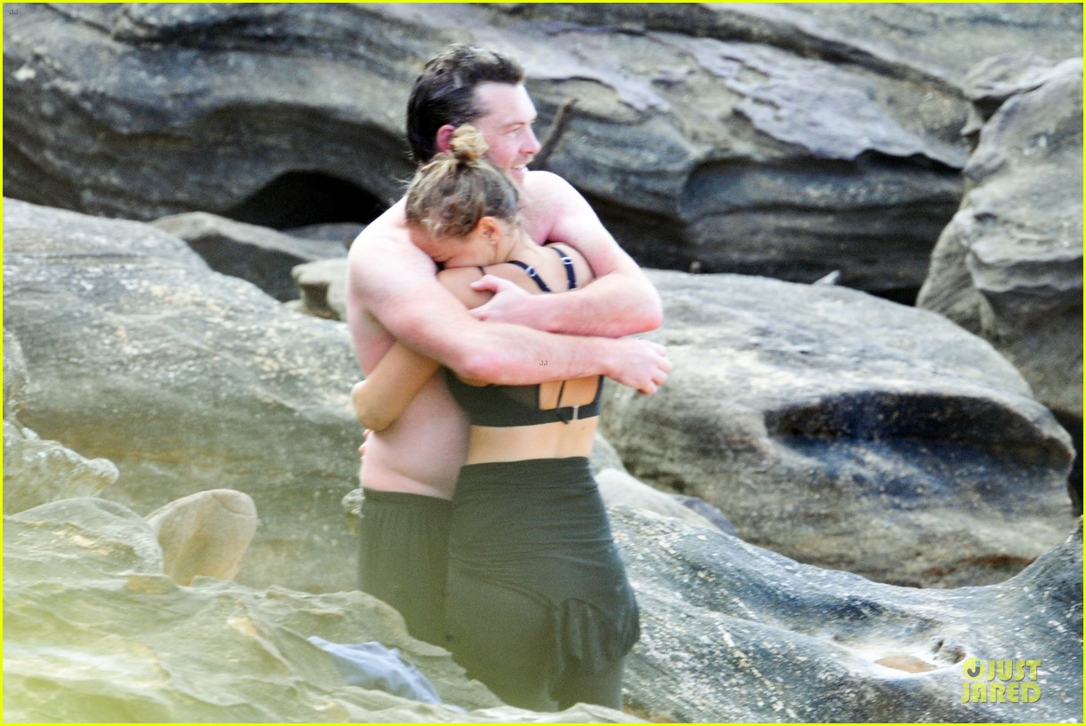 Sam Worthington goes shirtless while frolicking on the beach with his new g...