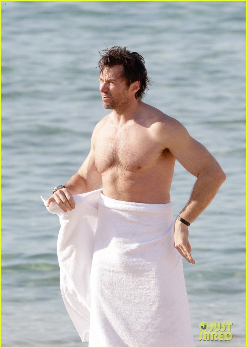 Hugh Jackman shows off his buff shirtless body while taking a quick swim at...