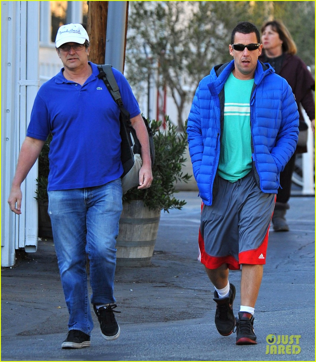 Adam Sandler keeps it casual in a puffy jacket and some basketball shorts w...