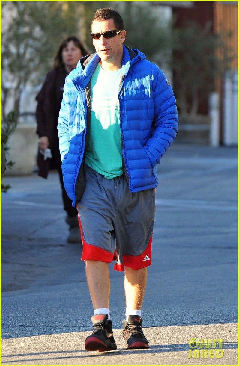 Adam Sandler keeps it casual in a puffy jacket and some basketball shorts w...