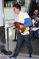 orlando bloom carries his cute dog through the airport 03