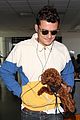orlando bloom carries his cute dog through the airport 04