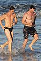 hugh jackman hits the beach with his speedo clad trainer 64